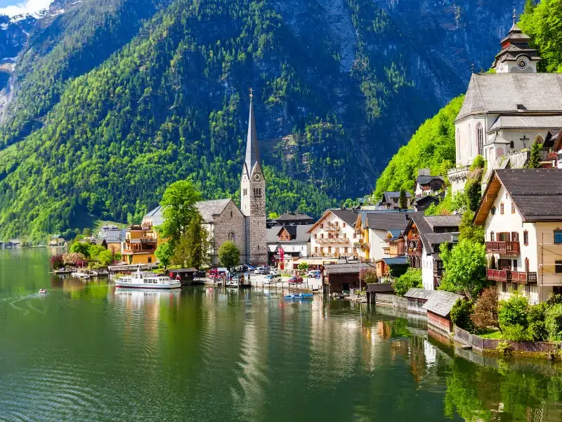 A lake with a small town and church on the banks backed by densly wooded mountains