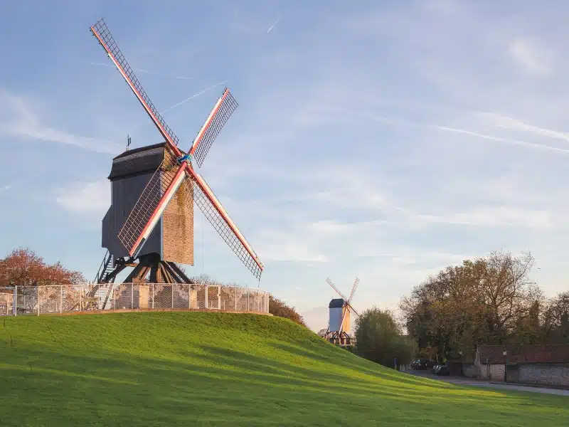 a Dutch windmill on a grassy hill