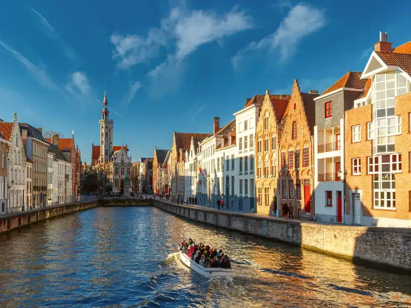 A canal boat in a canel surrouned by historic Dutch buildings